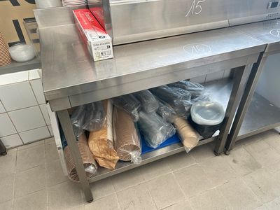 une table en acier inoxydable sur laquelle sont posés plusieurs sacs