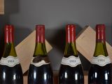 three bottles of wine are lined up in a row on a shelf