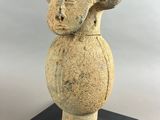 an image of a stone vase on a black stand on a gray background