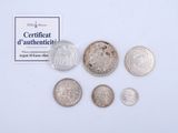 some coins are sitting on a white surface next to a certificate