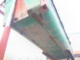 underside of a green and red boat sitting on top of a field