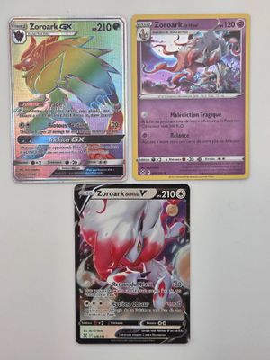 trois cartes Pokémon différentes posées sur une table avec un fond blanc