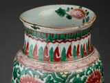 a green and red vase with flowers on it