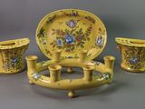 three pieces of yellow pottery on display on a table