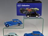 three toy cars are on display in front of a blue box