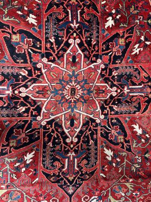 un tapis oriental orné d'un grand motif floral sur fond rouge
