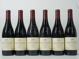 six bouteilles de vin rouge sont alignées sur une table