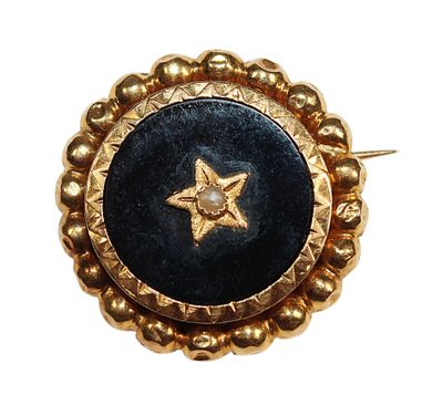 une image représentant une broche dorée et noire ornée d'une étoile