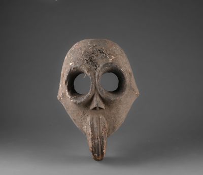 un gros plan d'un masque au long nez sur fond gris