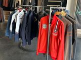 a lot of clothes hanging on a rack in a store