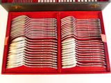 des couverts dans un étui rouge posé sur une surface blanche