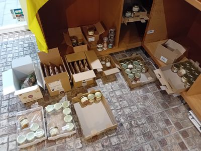 de nombreuses caisses remplies de bocaux et de récipients contenant de la nourriture, posées par terre