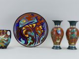 three vases and a plate sitting next to each other