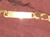 un bracelet en or muni d'une chaîne, posé sur une table