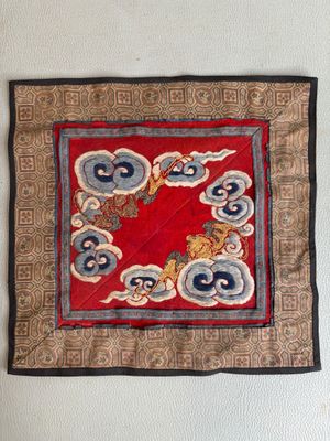 un carré rouge orné de motifs bleus et blancs accroché au mur