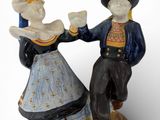 une figurine représentant un homme et une femme se tenant la main