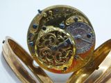 a gold pocket watch sitting on top of a white table