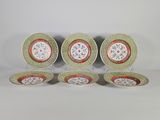 quatre assiettes ornées de motifs floraux, posées sur une surface blanche