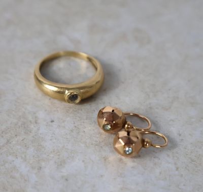 deux bagues en or et une bague sertie d'un diamant, posées sur une surface en marbre
