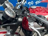 a red motorcycle parked in front of a graffiti covered wall