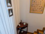 une photo d'un couloir avec un parquet et un tableau accroché au mur