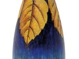 a blue vase with yellow leaves painted on it