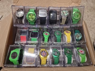 une boîte posée par terre, contenant de nombreuses montres différentes