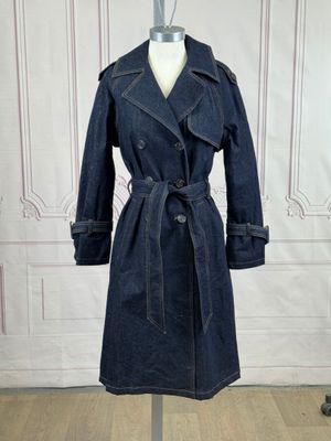 denim trench coat on a mannequin stand in front of a white wall