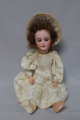 a doll that is sitting on the floor with a hat on