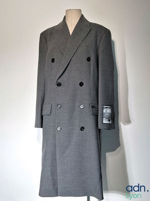manteau gris à double boutonnage posé sur un présentoir pour mannequin