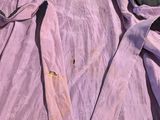 a pink shirt with a tie on a bed