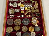 une vitrine en bois remplie d'une multitude de boutons de toutes sortes