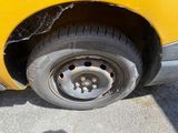 a close up of a tire on the side of a yellow car