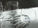 four empty glasses sitting on a table next to each other