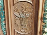 a carved door with a basket of fruit on it