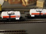 two toy trains that are sitting on the train tracks