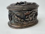 a silver box with a bird on it sitting on a table