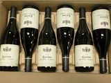 six bouteilles de vin dans un carton sur une table