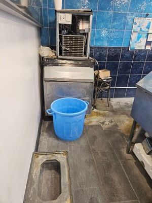 a blue bucket sitting on the floor of a kitchen