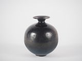 a black vase that is sitting on a white surface