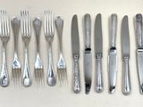 beaucoup de couverts sur une table, avec des fourchettes et des cuillères