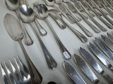 many spoons and forks laid out on a table