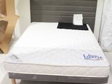 un lit sur lequel est posé un matelas dans une pièce
