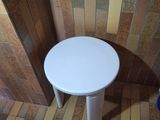 a small white table in the corner of a room