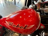 a red motorcycle parked in a showroom with other motorcycles