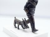 figurine of a man with a dog on a white base