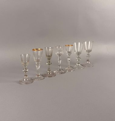 sept verres à vin alignés sur une table