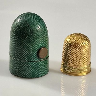 deux dés à coudre posés l'un à côté de l'autre sur une surface blanche