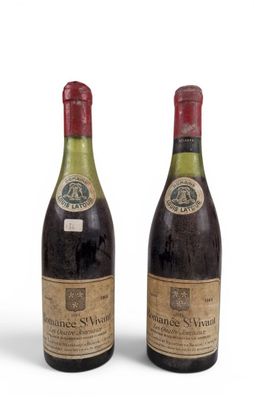 two bottles of wine sit next to each other on a white surface