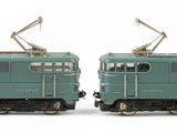 two toy trains sitting side by side on a white surface